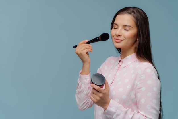 Glamour woman applies blush with makeup brush Premium Photo