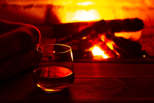 Premium Photo | Glass of alcoholic drink wine in front of warm fireplace. magical relaxed cozy atmosphere near fire