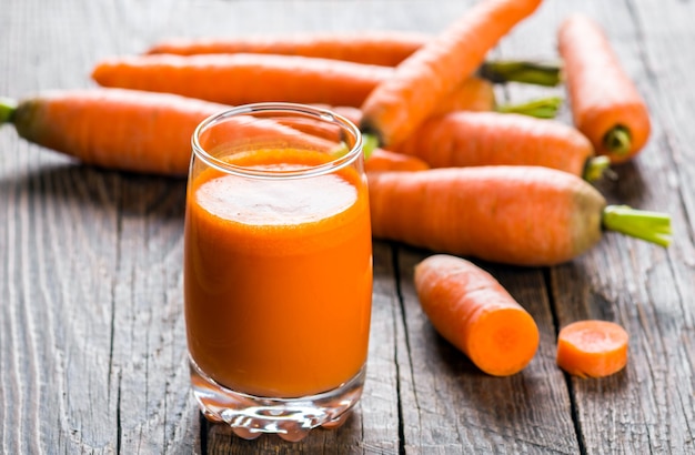 Premium Photo | A glass of fresh squeezed carrot juice on old rustic ...