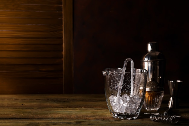 Dark Wood Tableware Bar glass ice bucket with bar accessories on dark wooden background premium photo