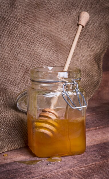 Download Premium Photo Glass Jar With Honey And Wooden Spoon On The Background