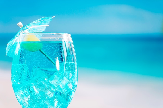 オリーブと傘で飾られた新鮮な青い飲み物のガラス 無料の写真