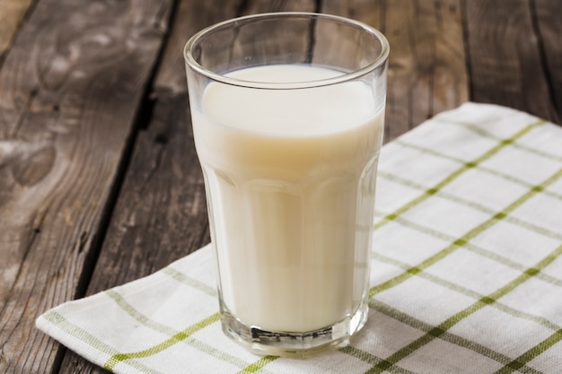 Glass of milk on white napkin over the wooden table Free Photo
