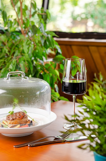 透明なキャップの下で野菜と赤ワインと子牛のメダリオンのガラス レストラン料理 プレミアム写真