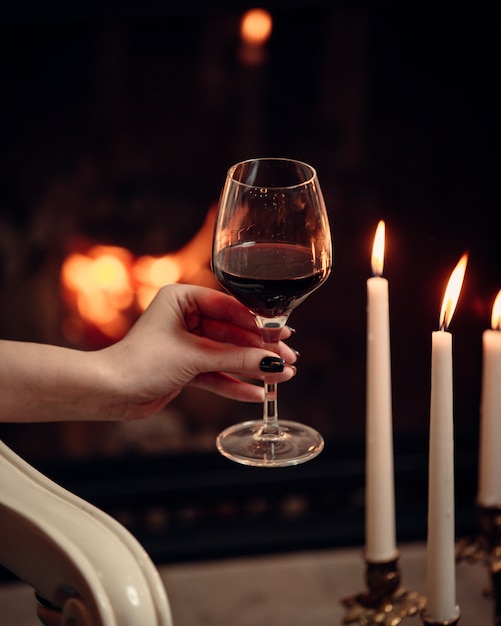 A glass of red wine  surrounded with candles  in romantic  