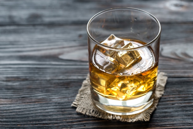 Premium Photo | Glass of rum on the wooden background