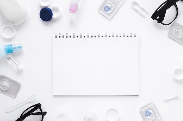 Glasses and optical objects with notebook mock-up on white background Free Photo