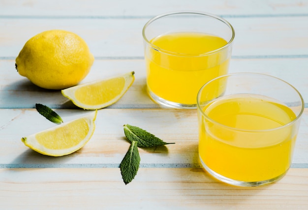 Free Photo | Glasses of refreshing yellow drink near lemon and mint