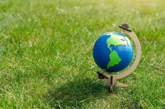 春または夏の晴れた日に緑の芝生の上に立っている地球の地球 プレミアム写真