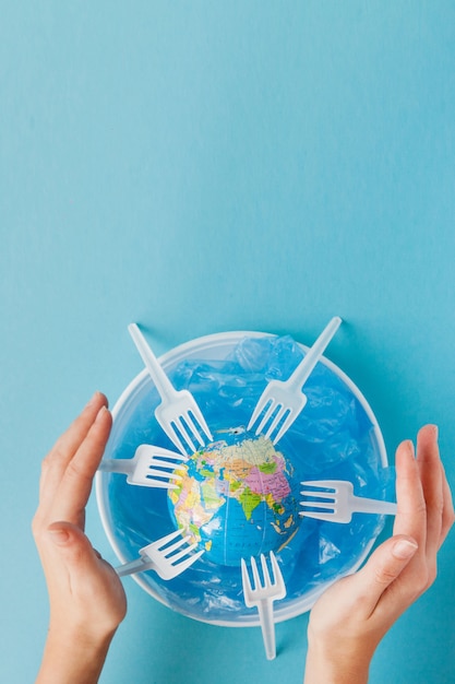 Globe on a plastic plate on blue background Premium Photo
