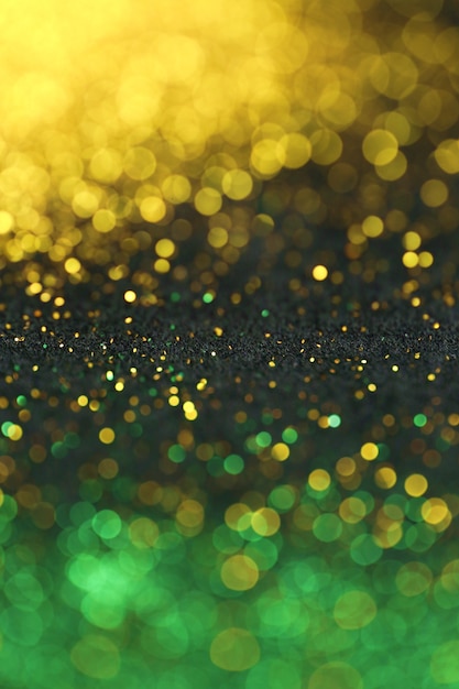 輝くボケ味を持つ金と緑のキラキラ背景 プレミアム写真