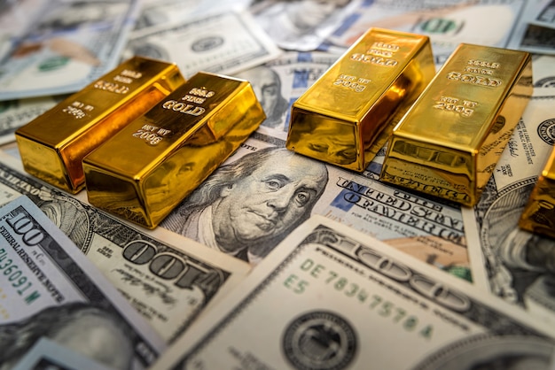 Premium Photo | Gold bar on 100 dollar bills. investment