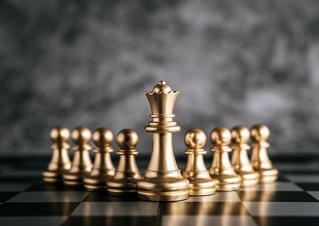 Gold chess on chess board game for business metaphor leadership concept Free Photo
