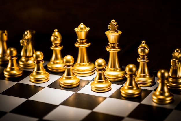 Premium Photo | Gold chess pieces on a chessboard