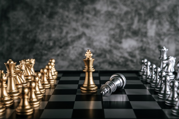 Gold and silver chess on chess board game for business metaphor leadership concept Free Photo