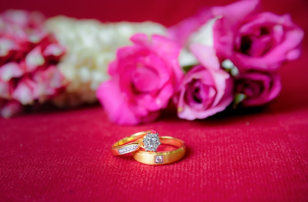 Premium Photo | Gold wedding ring and red a roses