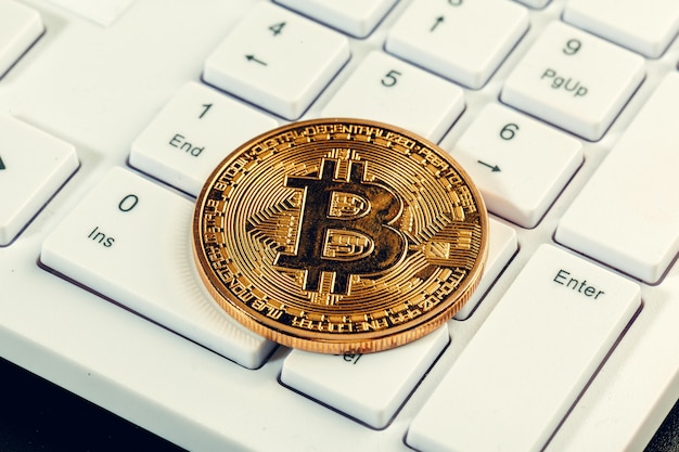 Golden bitcoin coin cryptocurrency on the laptop keyboard. Premium Photo
