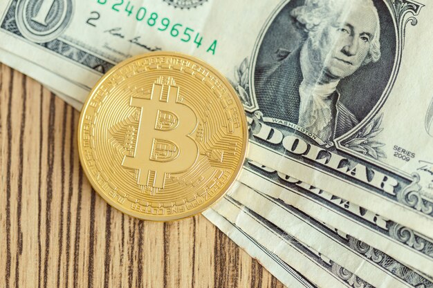 Golden bitcoin coin and one dollar banknote | Premium Photo