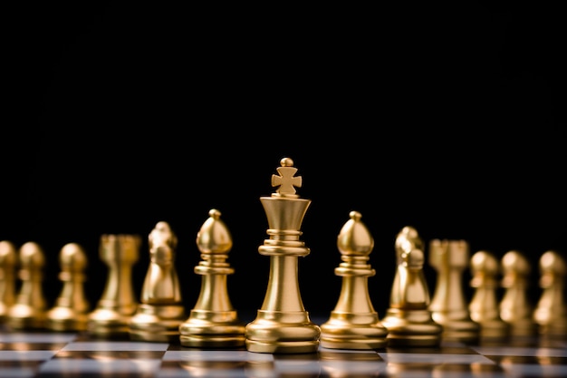 ゴールデンキングチェスは他のチェスの駒の前に立っています リーダーシップビジネスチームワークとマーケティング戦略計画コンセプト プレミアム写真