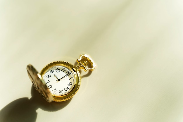 Premium Photo | Golden pocket watch on table with sunlight