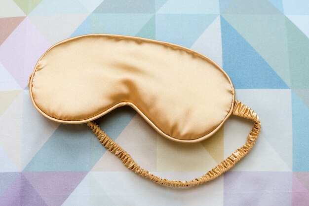 Premium Photo | Golden sleeping eye mask on the bed