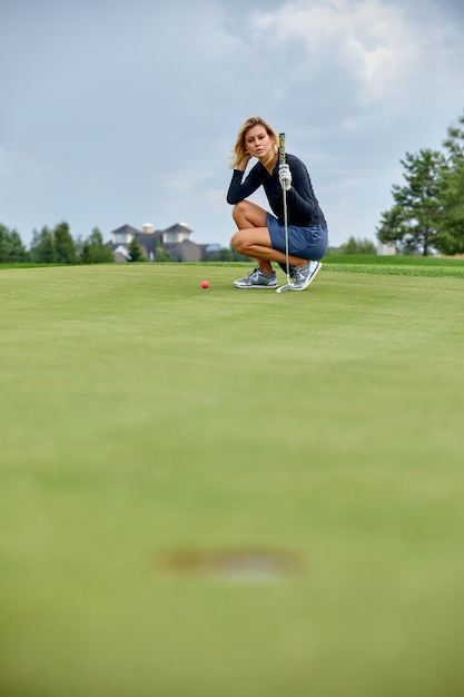 グリーンフィールドでの長いゴルフの試合の後に勝つゴルファーアクション 女の子はゴルフをしています ゴルフコンセプト 穴 プレミアム写真