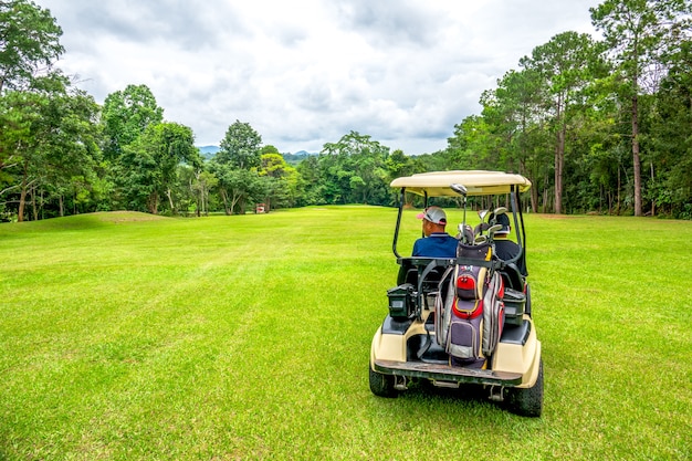 Premium Photo | Golfer driving club cart on fairway in golf course