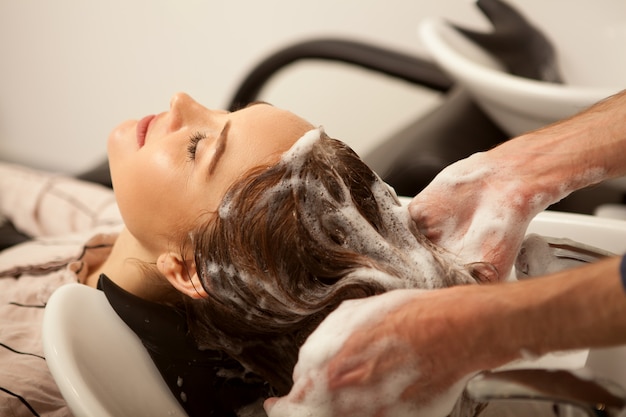 Gorgeous woman having her hair washed by hairdresser Premium Photo