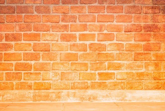 グラデーションオレンジ色のレンガの壁と製品のモンタージュの背景のためのクリーム色のコンクリートラインとスペース プレミアム写真