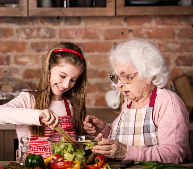 Premium Photo | Grandmother and granddaughter cooking together