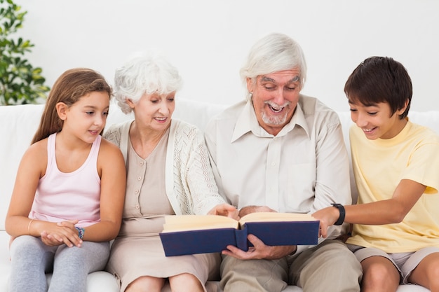 Premium Photo | Grandparents reading book with grandchlidren