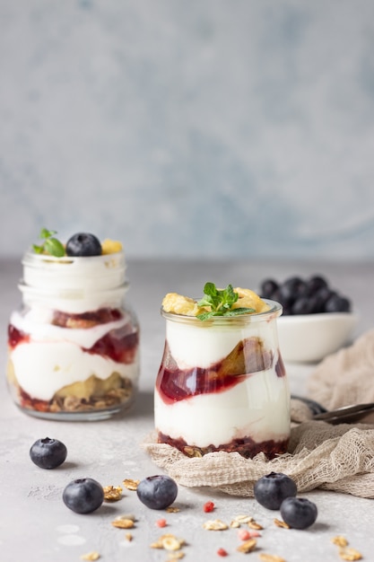 Premium Photo | Granola, blueberry and banana greek yogurt parfaits in ...