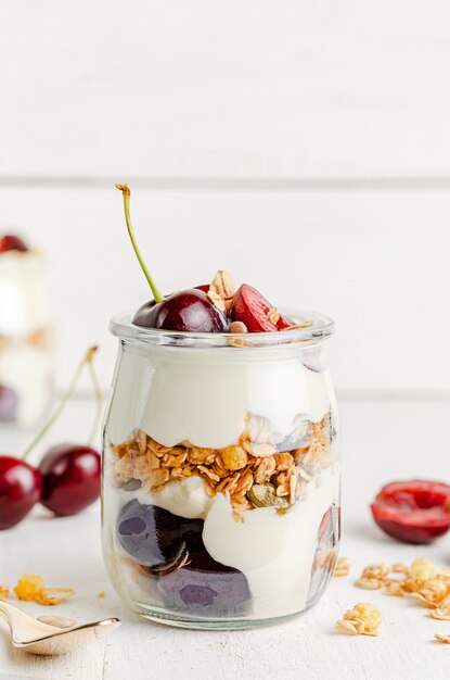 Premium Photo | Granola jar with greek yogurt and cherries. healthy ...