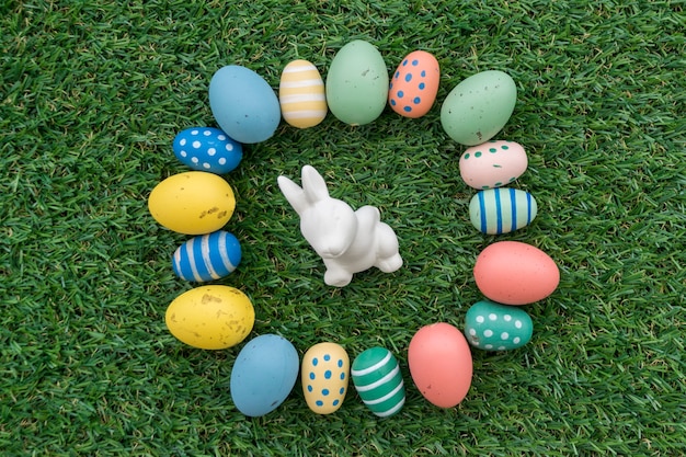 Free Photo | Grass background with easter bunny surrounded by colored eggs