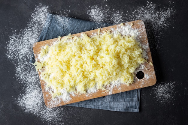 イタリア料理 ジャガイモニョッキの準備のための小麦粉をすりおろした茹でたジャガイモ 黒の背景 プレミアム写真