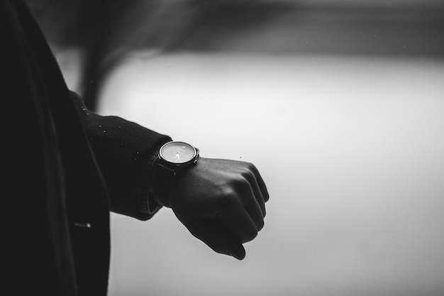 Grayscale closeup shot of a person wearing a wristwatch Free Photo