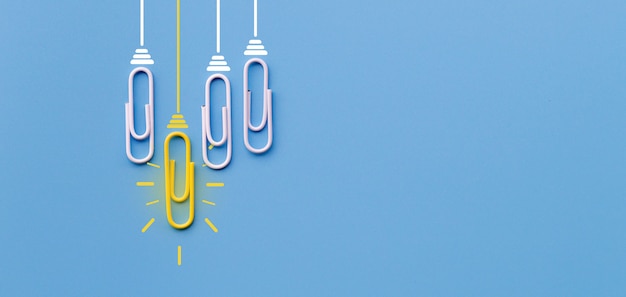 Great ideas concept with paperclip thinking creativity light bulb on blue background Premium Photo