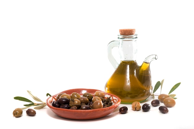 Premium Photo | Green and black olives with olive oil bottle