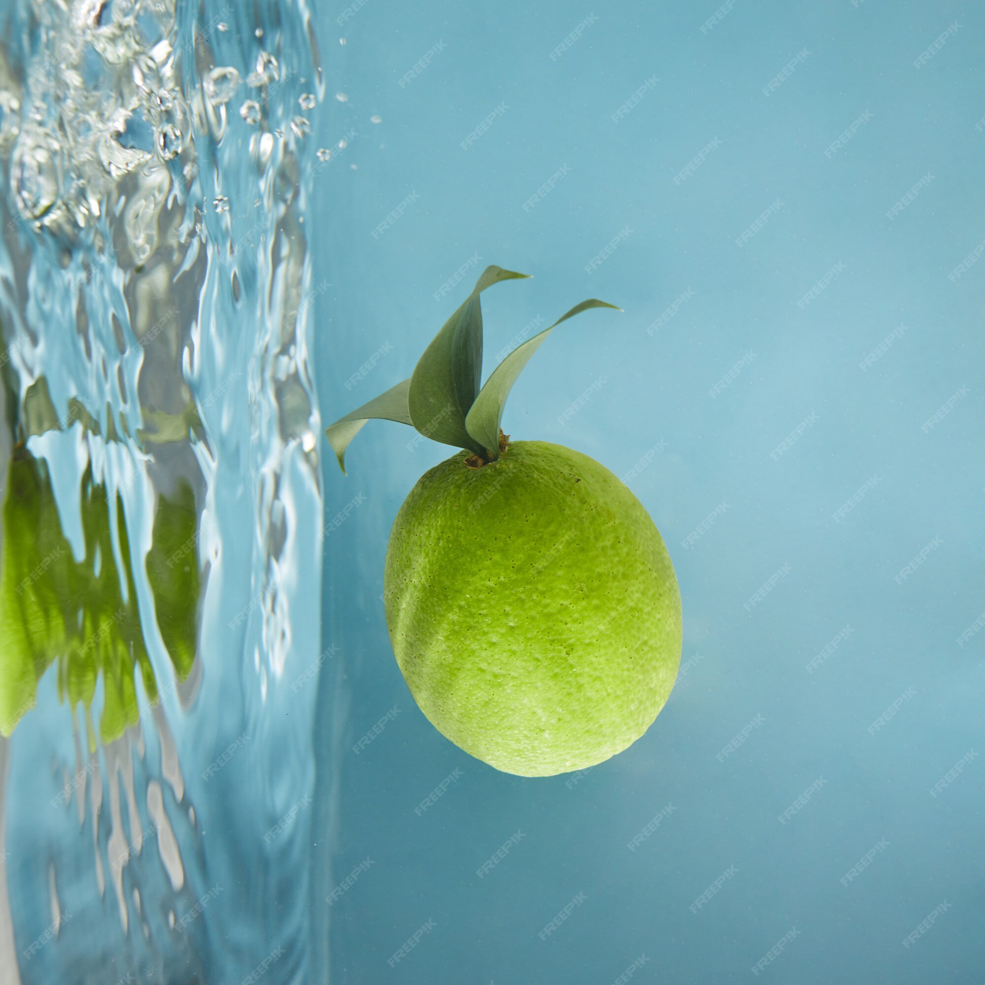 Premium Photo | Green fresh lime with leaves in water, a reflection of ...