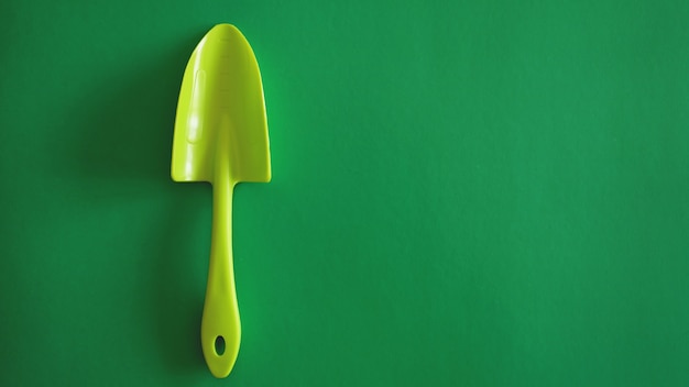 Premium Photo | Green garden tool on green background - top view and ...