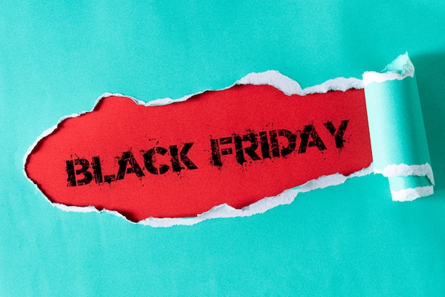 Green pastel torn paper and the text black friday on red. Premium Photo