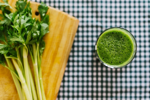 Green smoothie near celery on chopping board Free Photo