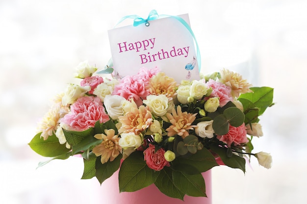花のグリーティングカード お祝いのメモ カード付きのチューブに大きな美しい花束 誕生日の花 母の日のためのブーケ 休日のコンセプト 3月8日 おめでとうございます プレミアム写真