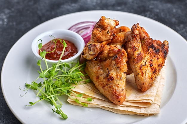 Premium Photo | Grilled chicken wings with barbecue sauce, pita bread ...