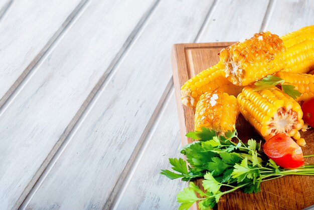 Grilled corn cobs with solt, spices and tomatoes Premium Photo
