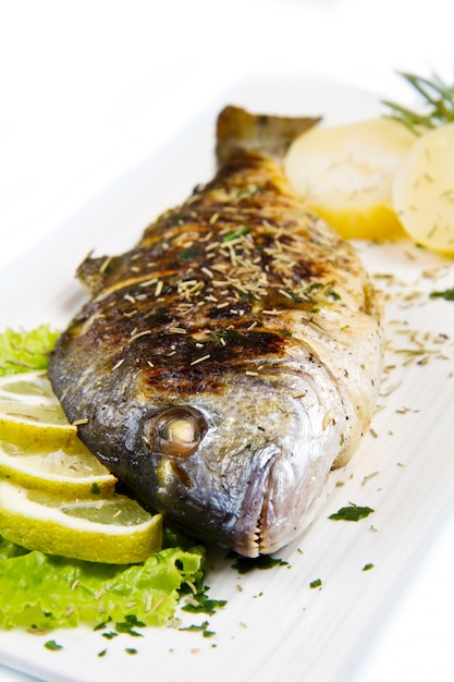 Premium Photo | Grilled gilt head sea bream on plate with lemon and ...