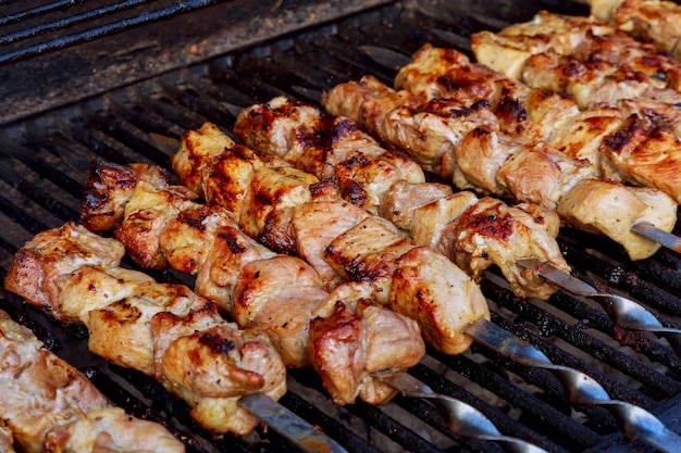 Grilled kebab cooking on metal skewer closeup. roasted meat cooked at ...