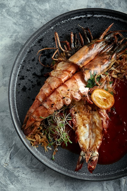 premium-photo-grilled-king-prawns-with-tomato-sauce-on-a-gray-low-key