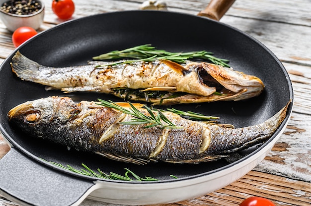 Premium Photo | Grilled seabass on white wooden table.