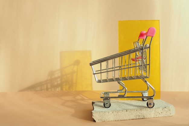 Premium Photo | Grocery cart on a concrete slab on a beige background ...